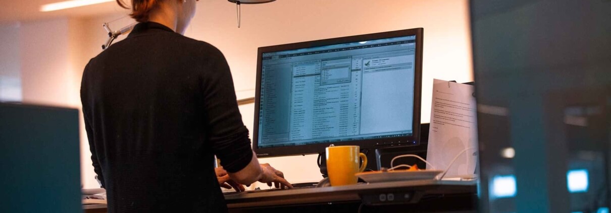 Kvinde foran en computer på et kontor