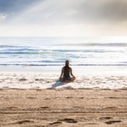 the-real-cbd-blog-kan-cbd-olie-hjælpe-fibromyalgi-patienter-yoga-på-stranden Kvinde på stranden i lotusstilling
