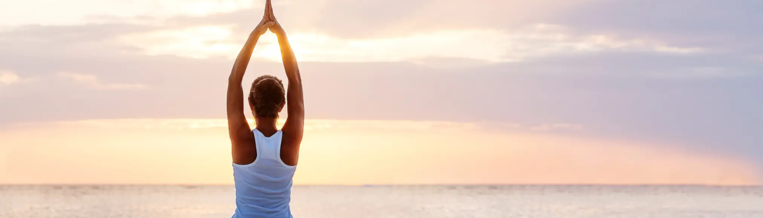 Kvinde i yogastilling på stranden