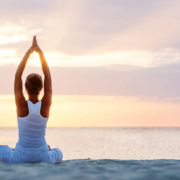 Kvinde i yogastilling på stranden