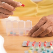 Medicin man IKKE skal tage med CBD olie! Person deler piller op i tablet-organisatorer