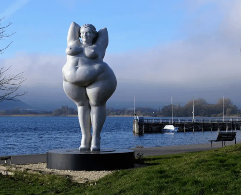 Voluptøs kvindestatue i en bådhavn