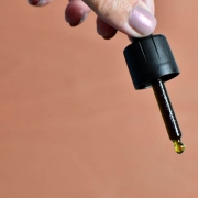 The-Real-CBD-Blog-Høj-kvalitet-cbd-olie Hånd holder dråbetæller med oliedråbe