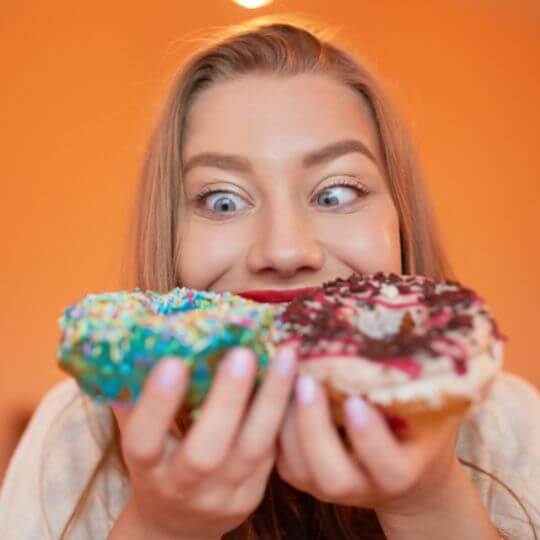 Kvinde spiser to donuts
