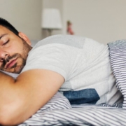 The-Real-CBD-Blog-De-Bedste-CBD-produkter-til-soevn Mand sover trygt på maven i en frisk seng