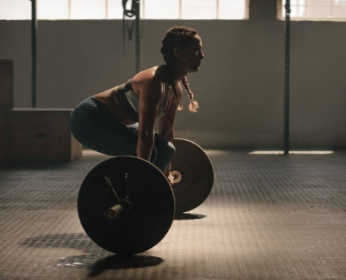 Kvinde løfter en vægtstang i et funktionelt fitnesscenter