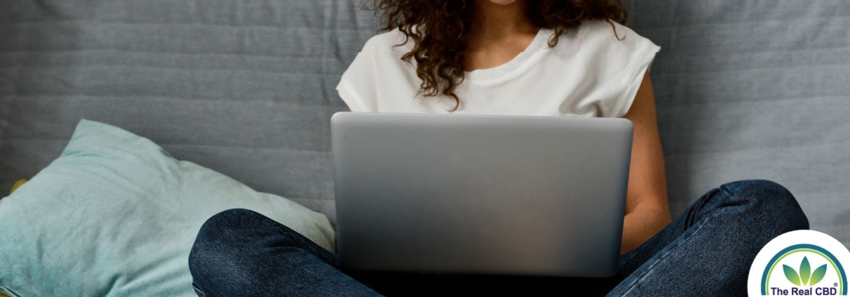 Teenager arbejder på en laptop i sengen