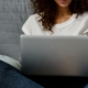 Teenager arbejder på en laptop i sengen