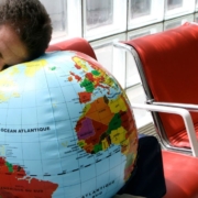 Mand sover med hovedet på en globus i en lufthavn