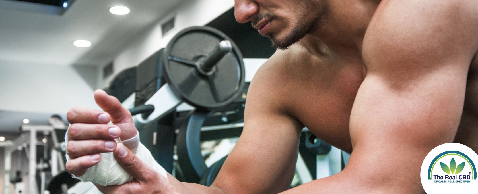 Mand i fitnesscenter med bandage om håndleddet