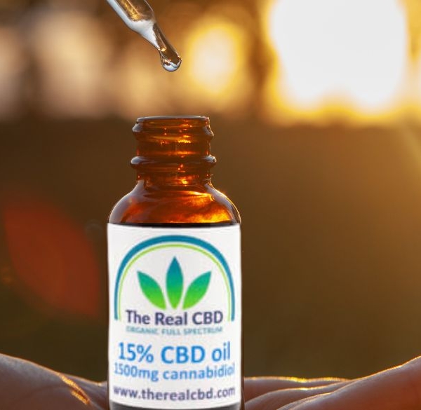 Den ægte CBD-tinkturflaske på en flad hånd