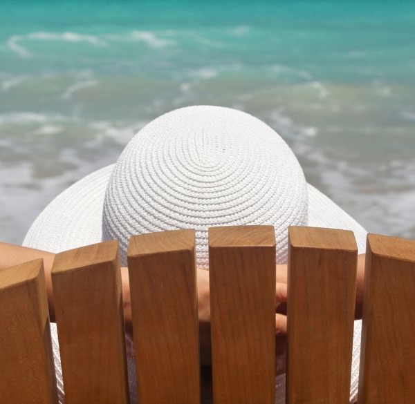 Kvinde sidder i strandstol ved havet og slapper af
