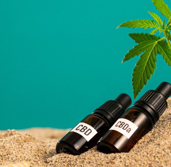 CBD- og CBA-olieflasker i sandet