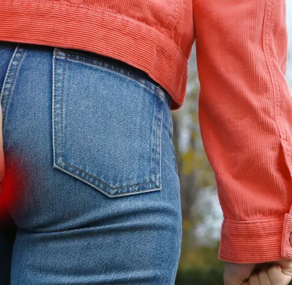 Kvinde holder sin bagdel, mens hun går op ad trappen