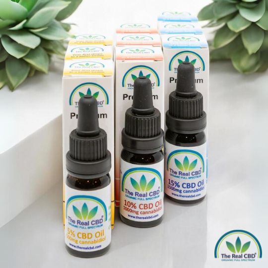 3 flasker CBD olie på et bord med planter