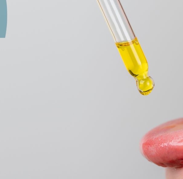 Person drypper CBD olie på tungen