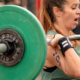 Kvinde lofter tung Barbell over hovedet