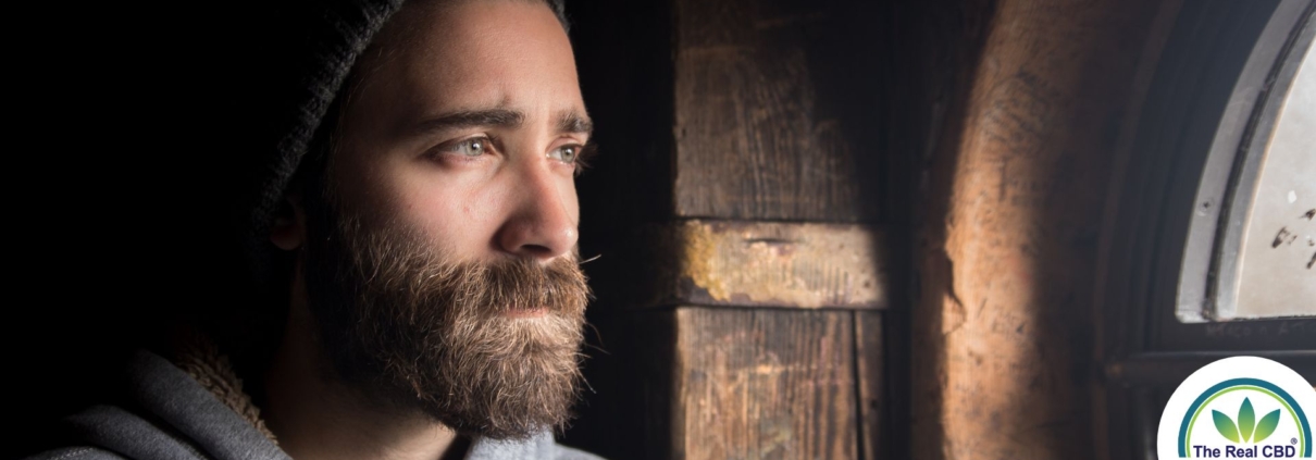Mand kigger ud af vinduet med depressivt udtryk