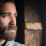 The-Real-CBD-Blog-CBD-til-dystymisk-depressiv-lidelse Mand kigger ud af vinduet med depressivt udtryk