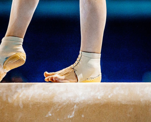 En gymnasts fødder på en bar