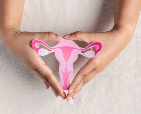 Kvinde holder pink udklip af en livmoder