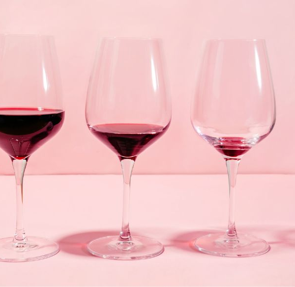 Række med rødvinsglas med mindre og mindre vin i