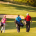 4 golfspillere går hen over greenen