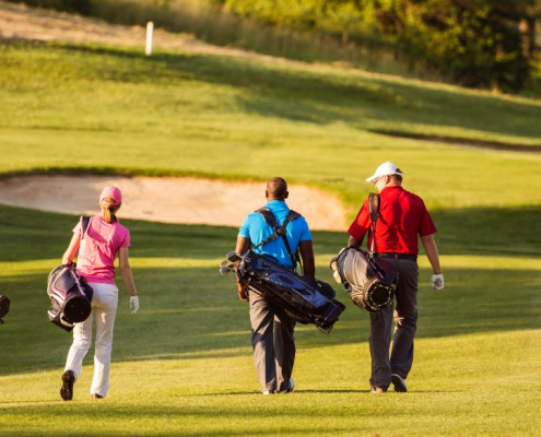4 golfspillere går hen over greenen