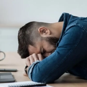 the-real-cbd-blog-CBD-til-Stills-sygdom Mand sover henslængt over et skrivebord