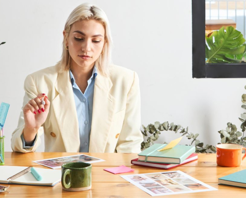 Kvinder sidder og arbejder ved et fyldt skrivebord