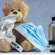 the-real-cbd-blog-CBD mod kighoste hos børn Hostesaft og CBD staar sammen med en bamse