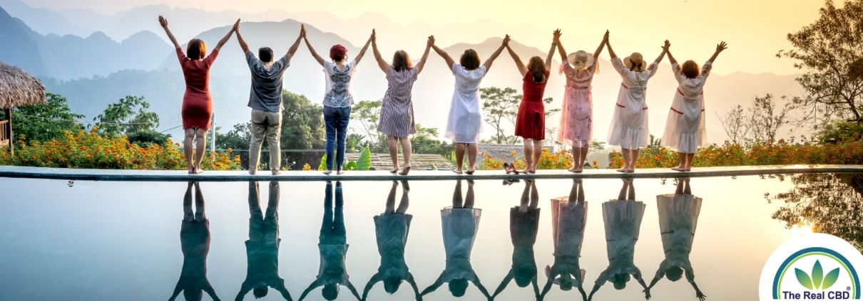 A row of happy people standing celebrating life on the edge of a pool