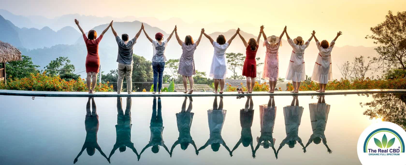 A row of happy people standing celebrating life on the edge of a pool