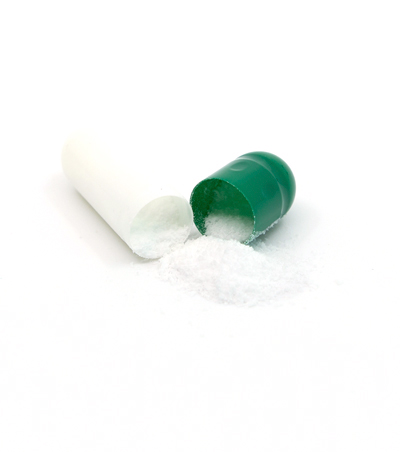 Cápsula de CBD abierta con polvo que cae - The Real CBD marca