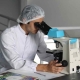 Científico en el laboratorio mirando por el microscopio