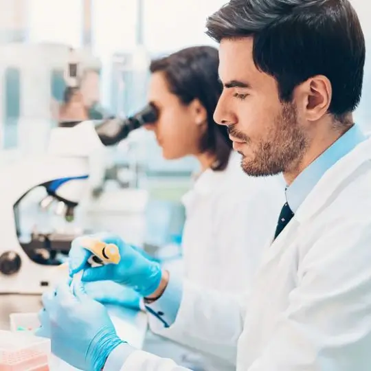 Científicos mirando por un microscopio en un laboratorio