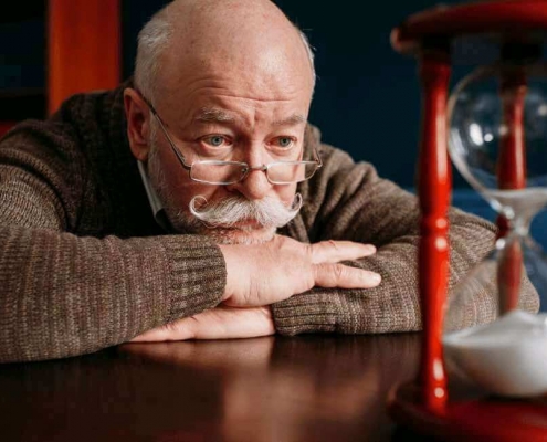Anciano observando un reloj de arena