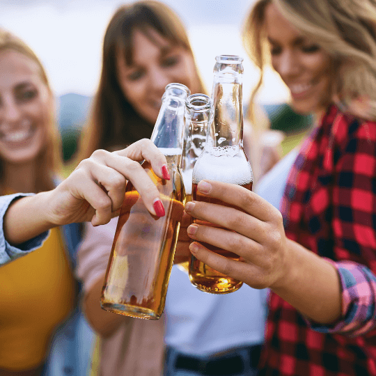 3 mujeres jóvenes animando con botellas de cerveza