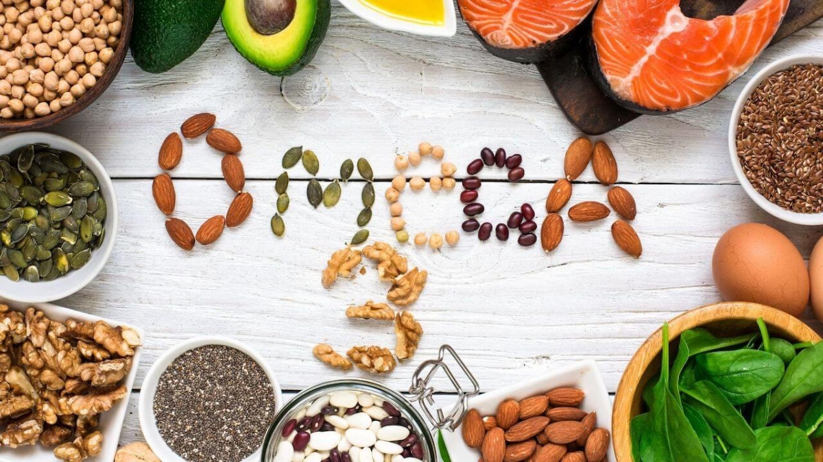 OMEGA 3 escrito en comida sobre mesa de madera con alimentos sanos alrededor