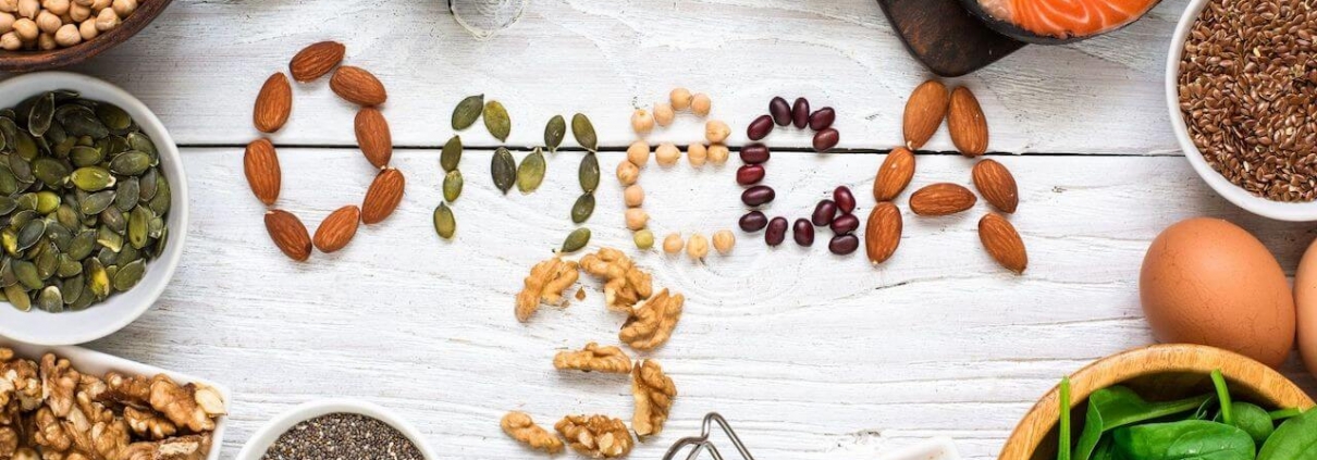 OMEGA 3 escrito en comida sobre mesa de madera con alimentos sanos alrededor