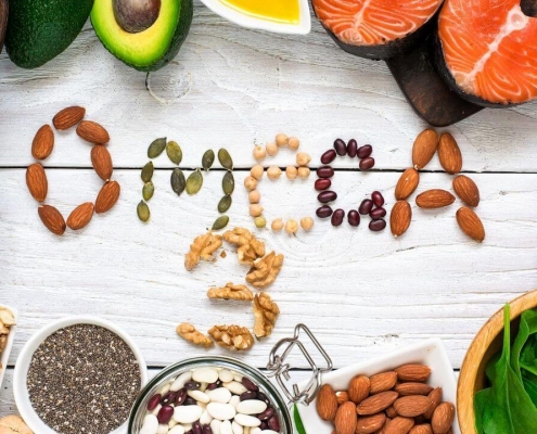 OMEGA 3 escrito en comida sobre mesa de madera con alimentos sanos alrededor