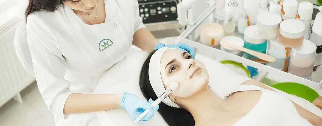 Esteticista tratando a una mujer con una mascarilla facial