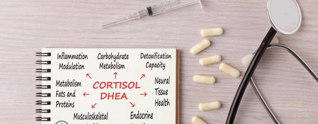 Cuaderno de cortisol sobre una mesa con cápsulas y un estetoscopio