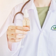 The-Real-CBD-Cuanto-CBD-puedes-tomar Médico con una botella de aceite en la mano