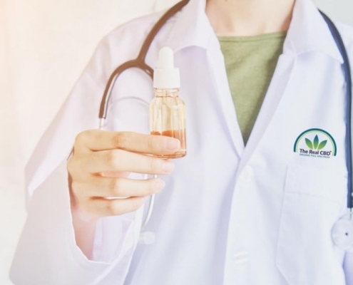 Médico con una botella de aceite en la mano