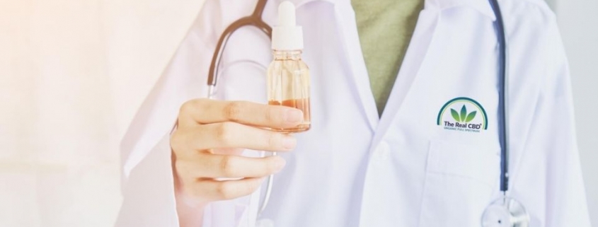 Médico con una botella de aceite en la mano