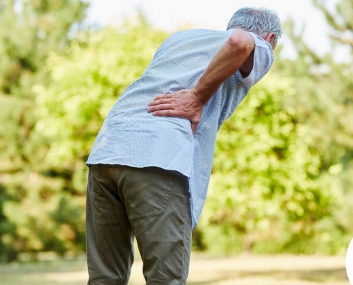 Hombre sujetándose la parte baja de la espalda por el dolor