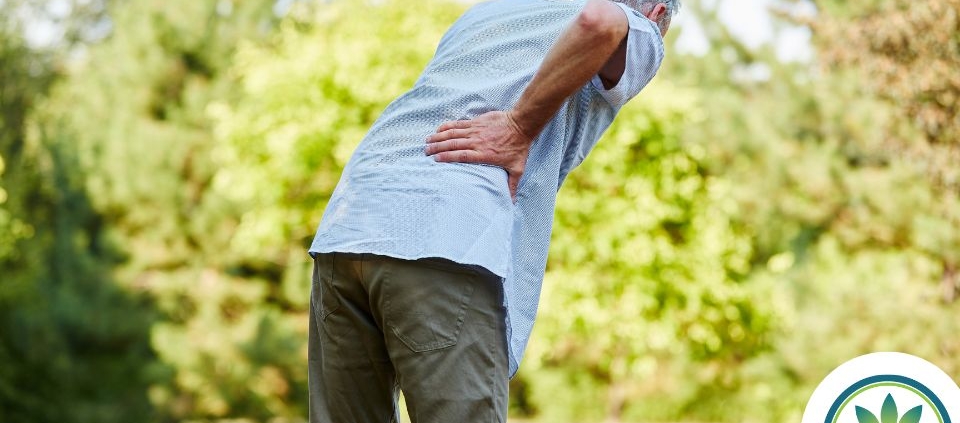 Hombre sujetándose la parte baja de la espalda por el dolor