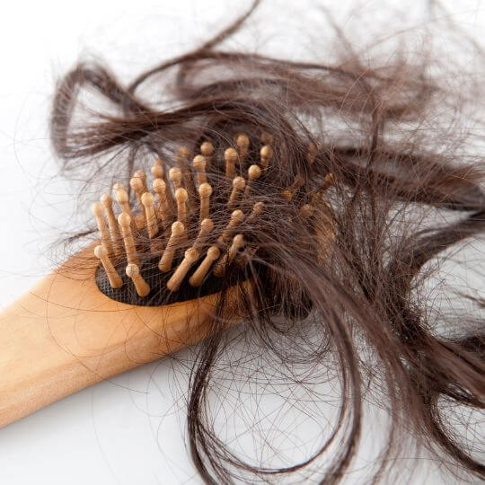 Un cepillo lleno de pelo largo castaño