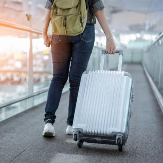 Mujer caminando con su equipaje de mano en un aeropuerto